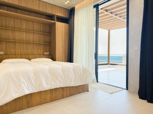 a bedroom with a bed and a view of the ocean at Villa 4 - Drymades - Thymus Residence in Dhërmi +24 photos