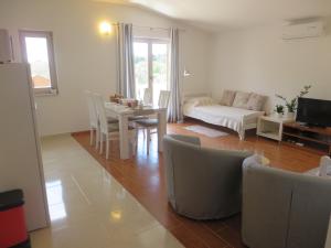sala de estar con sofá, mesa y sillas en Filipovic Apartments with Pool, en Biograd na Moru