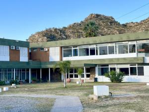 a building with a mountain in the background at Hotel ACA Chilecito in Chilecito
