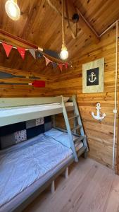 a bedroom with a bunk bed in a wooden cabin at Carpinus I domek nad jeziorem in Łętowo