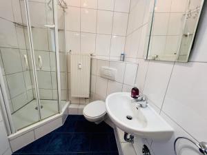 a bathroom with a sink and a toilet and a shower at Kajuete, direkt am Kurpark in Warnemünde +15 photos