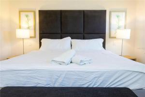 a large white bed with two towels on it at 3065 YL - Cozy 2BR Townhome - Encantada in Kissimmee