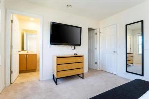 a living room with a flat screen tv on a wall at 3065 YL - Cozy 2BR Townhome - Encantada in Kissimmee +15 photos