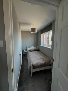 a small bedroom with a bed and a window at Two bed flat in Cardiff in Cardiff