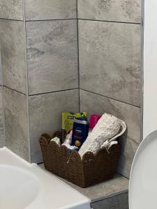 a basket of toiletries sitting on a counter in a bathroom at Two bed flat in Cardiff in Cardiff +3 photos