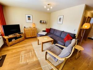 a living room with a couch and a tv at Ferienhaus Ostseeperle in Warnemünde