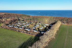 an aerial view of a farm with a field and the ocean at Ferienhaus Ostseeperle in Warnemünde +9 photos