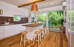 a kitchen with white cabinets and a counter with stools at Villa River home by WH by Villas Guide 