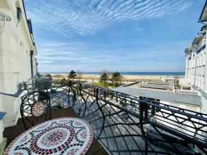 a balcony with a table and a view of the beach at Ostseeliebe, direkt an der Promenade in Warnemünde