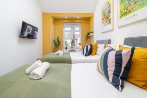 a group of three beds in a room at Large 4BR Contractor-Friendly House - Sleeps 10 - Free parking - North London in Enfield