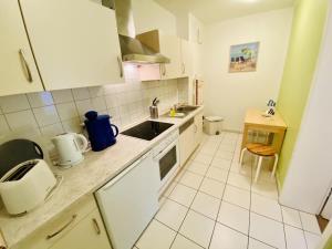 a small kitchen with white cabinets and a sink at Landhaus Immenbarg, Sonne in Warnemünde