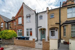 an image of a white house with brick buildings at Large 4BR Contractor-Friendly House - Sleeps 10 - Free parking - North London in Enfield