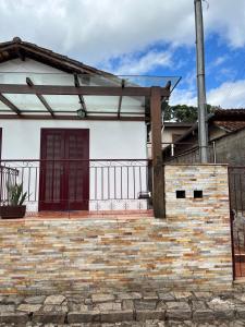 a white house with a red door and a fence at Cantim d' Casa in Catas Altas