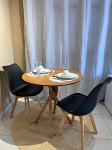 a wooden table with two chairs and two glasses at Cantim d' Casa in Catas Altas +7 photos
