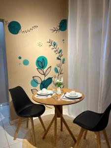 a dining room table with two chairs in front of a wall at Cantim d' Casa in Catas Altas
