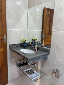 a bathroom with a sink and a mirror at Cantim d' Casa in Catas Altas
