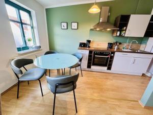 a kitchen with a table and chairs in a room at Haus Juliane, Kuestenlinie in Warnemünde