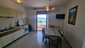 a kitchen with a table and a table and chairs at Apartments DEXI in Banjol