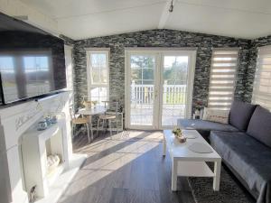 a living room with a couch and a table at Sunny corner caravan in Saint Osyth