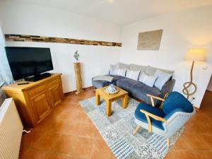 un salon avec un canapé et une télévision dans l'établissement Ferienhaus Strandkoje, à Warnemünde 13 autres photos