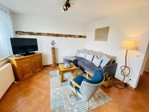 un salon avec un canapé et une télévision dans l'établissement Ferienhaus Strandkoje, à Warnemünde