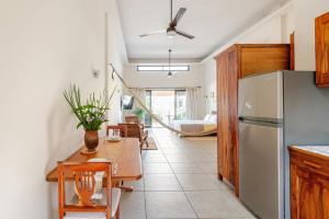 een keuken met een tafel en een koelkast bij Casa Hibiscus Zaachila 2 A in Puerto Escondido