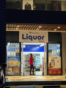 a person standing in front of a liquor store at Cozy 1BR Hideout Kilimani in Nairobi +14 photos