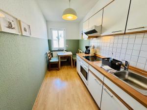 a kitchen with a sink and a table at Haus Juliane, Seesand in Warnemünde