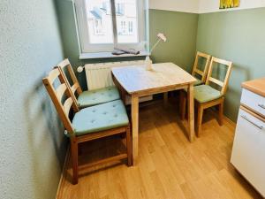 a kitchen with a table and chairs and a window at Haus Juliane, Seesand in Warnemünde +8 photos