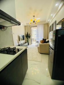a kitchen and living room with a stove and refrigerator at Cozy 1BR Hideout Kilimani in Nairobi