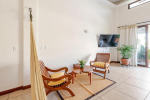 een woonkamer met stoelen en een hangmat in een kamer bij Casa Hibiscus Zaachila 2 A in Puerto Escondido