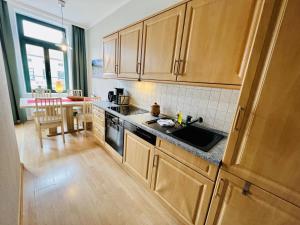 a kitchen with wooden cabinets and a sink and a table at Haus Juliane, Strandliebe in Warnemünde