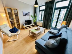 a living room with a blue couch and a chair at Haus Juliane, Neptun in Warnemünde