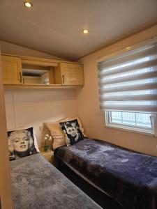 una camera da letto con due letti e una finestra di Sunny corner caravan a Saint Osyth
