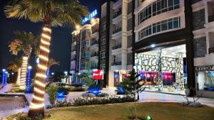 a palm tree in front of a building at night at جوليانا in Dawwār Muşādif Yūnus