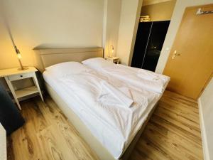 a large white bed in a small room at Haus Juliane, Neptun in Warnemünde