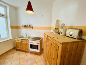 una cucina con lavandino e bancone con forno a microonde di Haus Juliane, Strandidyll a Warnemünde