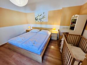 una camera da letto con un letto con lenzuola blu e uno specchio di Haus Juliane, Strandidyll a Warnemünde