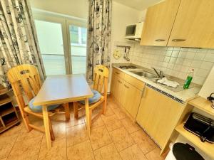 a kitchen with a table and chairs and a sink at Appartement Schwalbenflug in Warnemünde