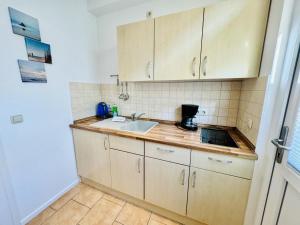a kitchen with wooden cabinets and a sink at Appartement Feuerdorn in Warnemünde