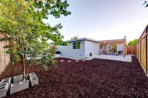 einen Hinterhof mit einem Baum und einem Haus in der Unterkunft @ Marbella Lane – Contemporary Sophisticated Home in Sunnyvale