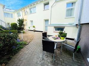 a patio with a table and chairs in front of a building at Appartement Sonnenflut in Warnemünde