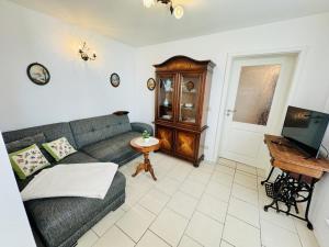a living room with a couch and a television at Appartement Eibeneck in Warnemünde