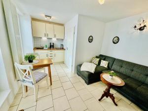 a living room with a green couch and a table at Appartement Eibeneck in Warnemünde +7 photos