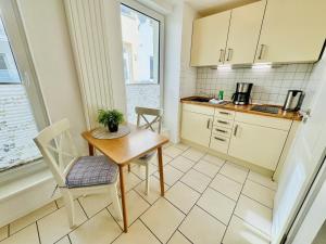 a kitchen with a table and chairs and a window at Appartement Eibeneck in Warnemünde