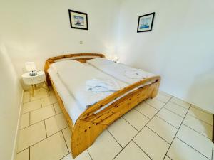 a bedroom with a wooden bed in a room at Appartement Eibeneck in Warnemünde