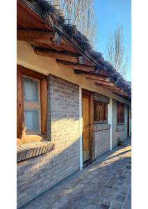 una casa de ladrillo con dos ventanas y una puerta de madera en Serena Cumbre Lodge, en San Rafael