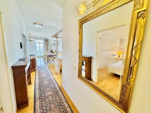 a large gold mirror on a wall in a living room at Sonnenaufgang, direkt am Alten Strom in Warnemünde