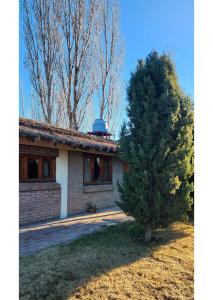 una pequeña casa con un árbol delante en Serena Cumbre Lodge, en San Rafael