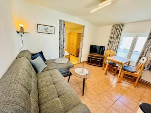 a living room with a couch and a table at Appartement Schwalbenflug in Warnemünde